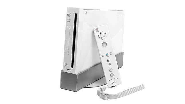 A white Wii with a Wii-mote leaning on it.